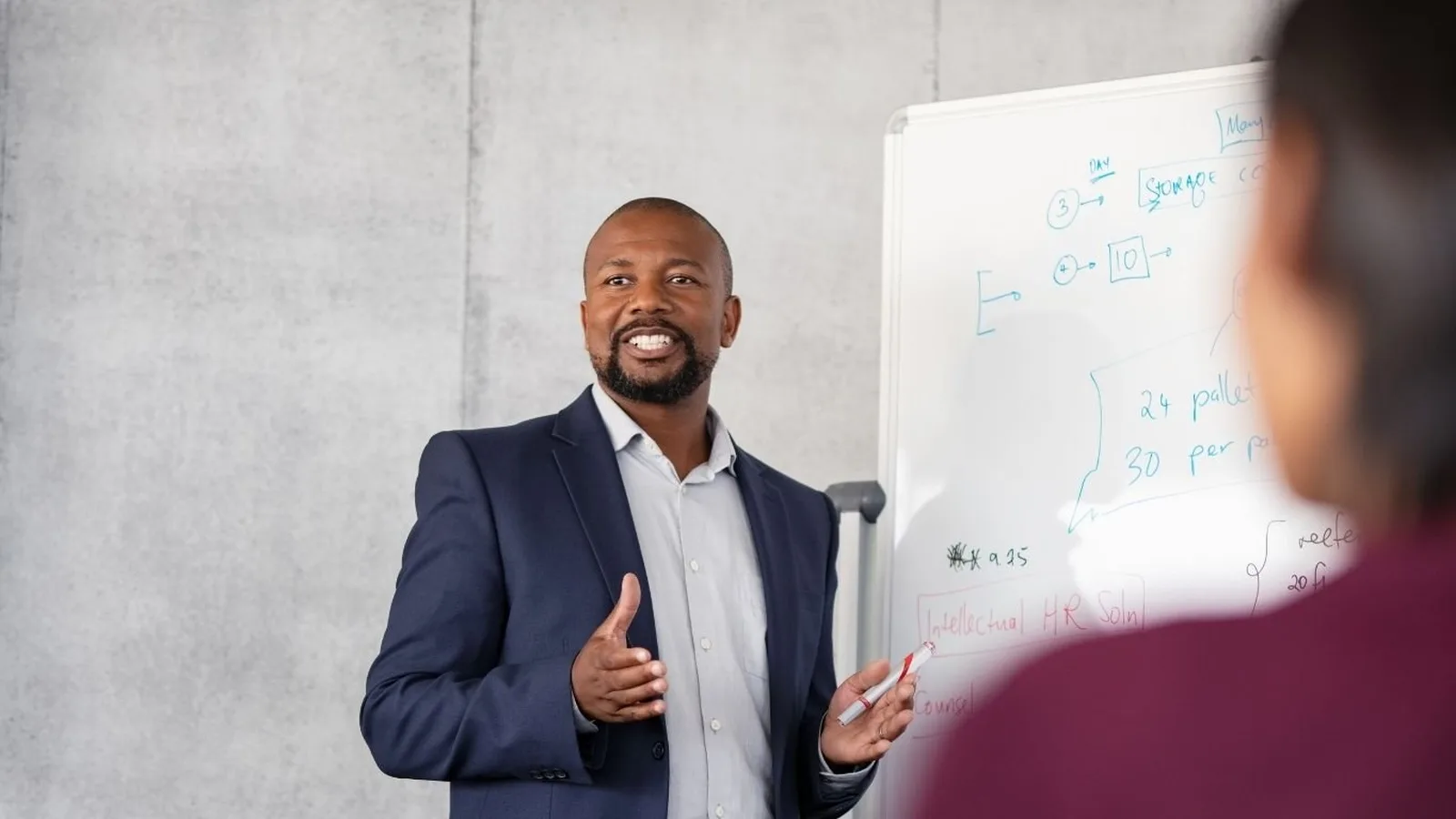 Manager commerciale en débrief avec un vendeur devant un tableau de bord d'indicateurs d'équipe